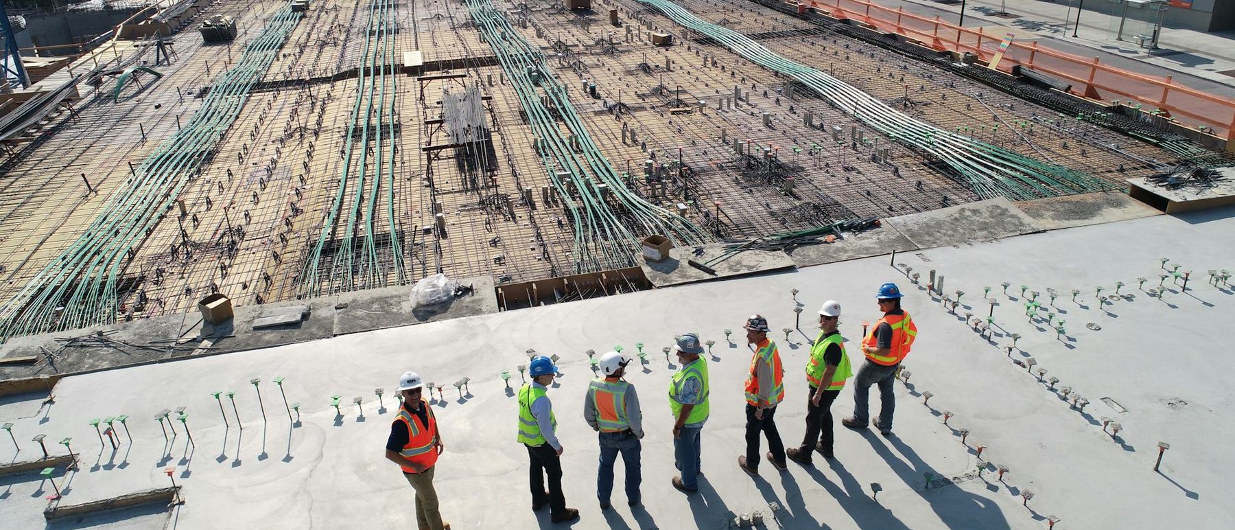 A site crew in high-visibility vests and hard hats on a prepared slab